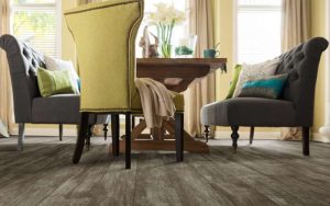 Gray-brown plank flooring in a room with seaweed-green chairs